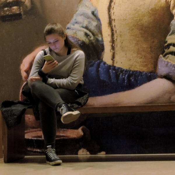 Girl reading asmart-phone at Vermeer exhibition